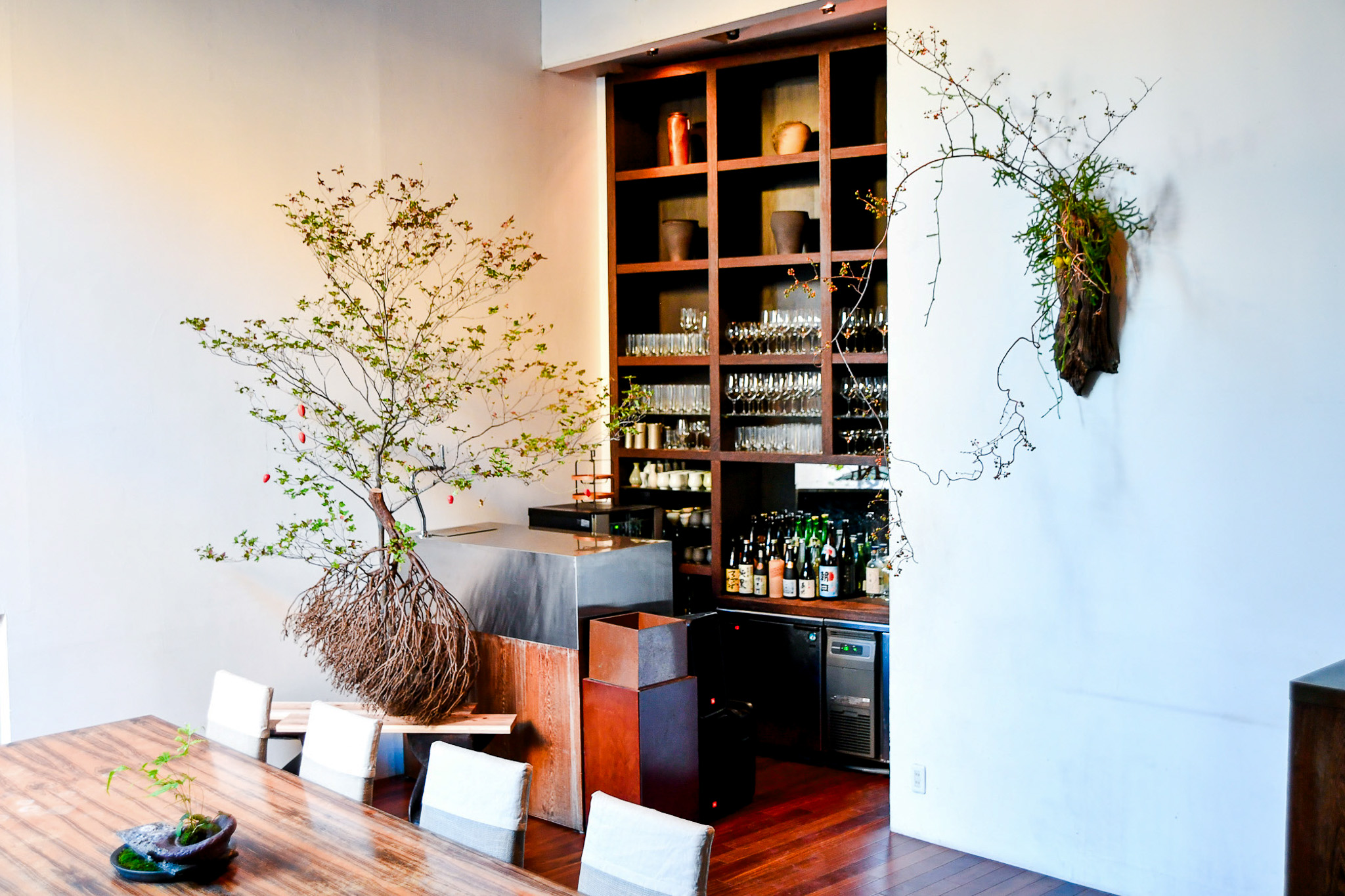 Ikebana installation in relation to table setting and dining room